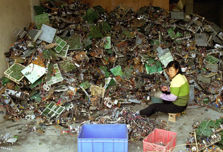 Woman sifting through electronic waste.