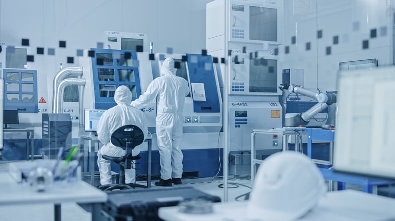 Electronic manufacturers wearing labcoats working in a lab.