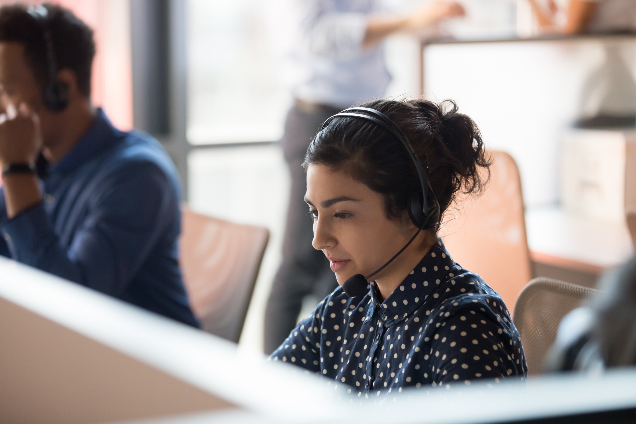 Person speaking to a customer on a wireless headset.