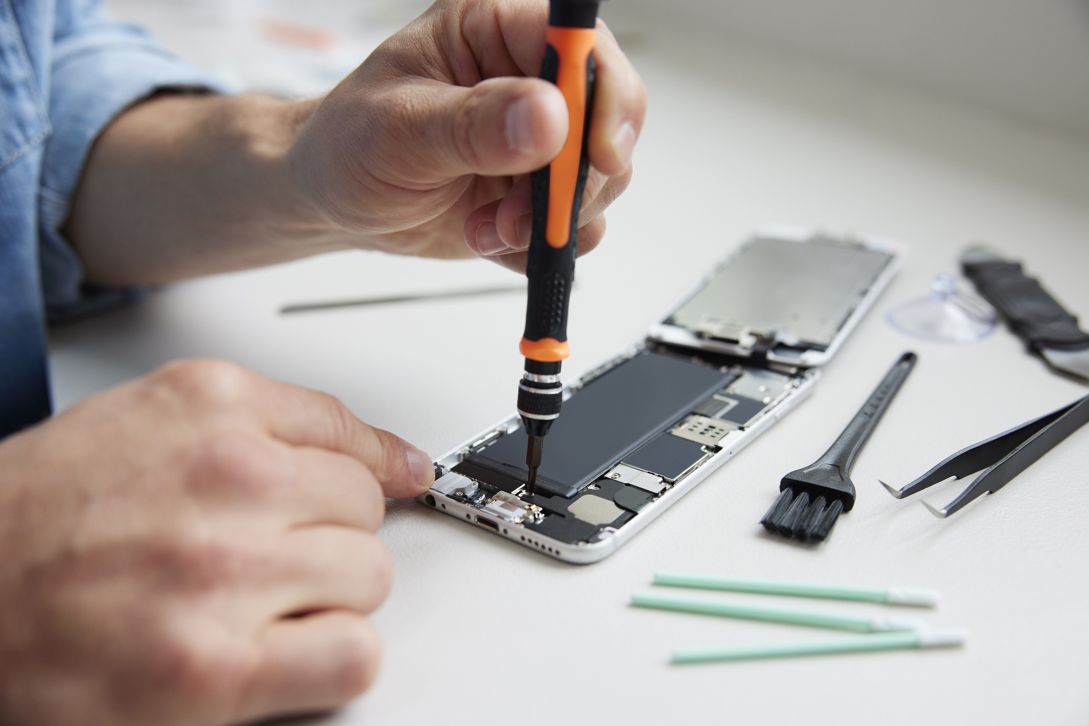 Close up of a person repairing a smart phone.