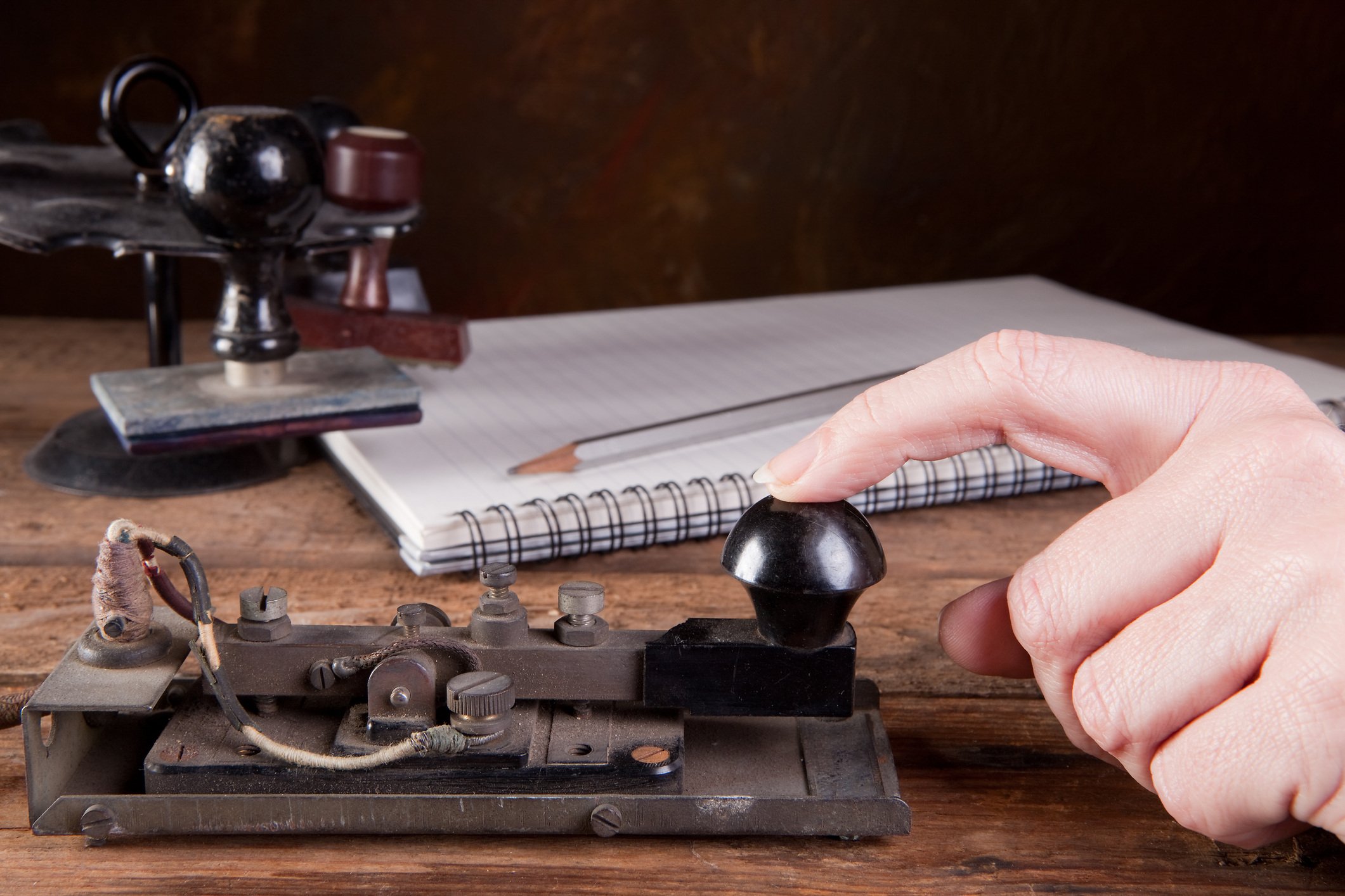 Antique telegraph machine being used.